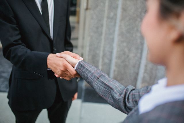 two%20people%20in%20business%20attire%20shaking%20hands
